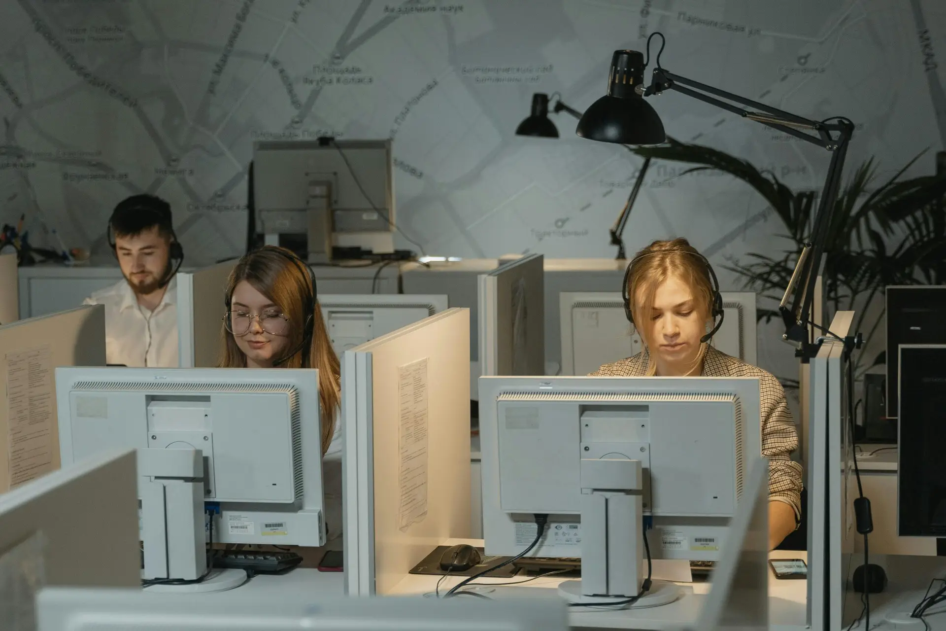 Call center agents working diligently with computers and headphones, providing customer support.